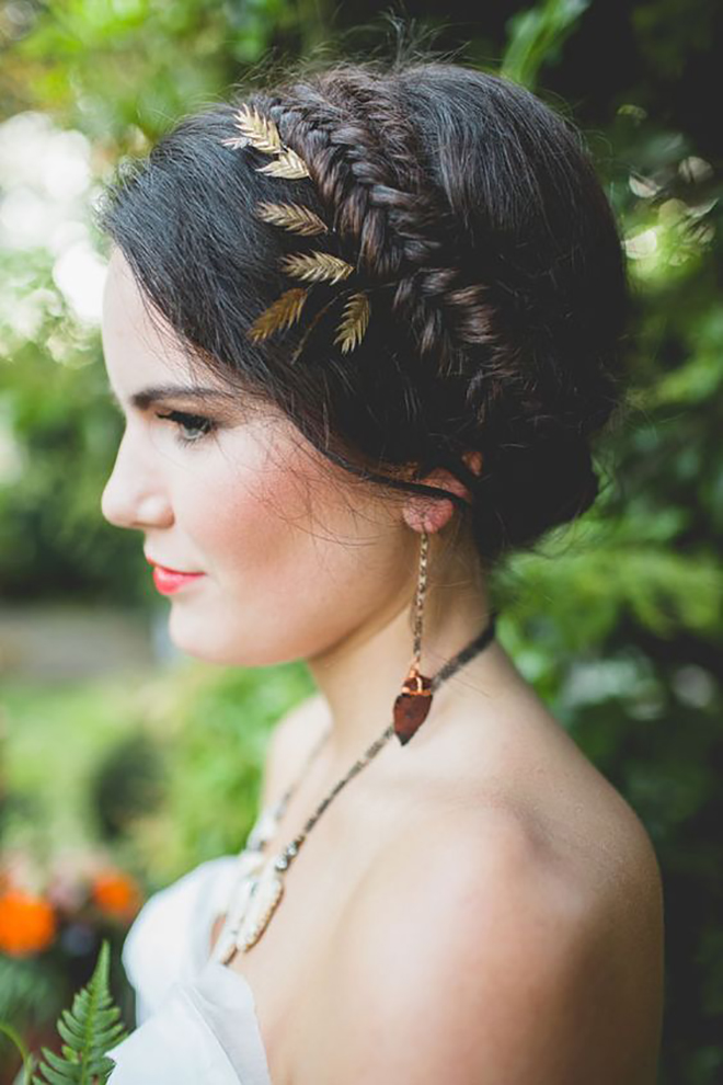 A braided crown with dainty leaves is a great winter wedding hair idea.