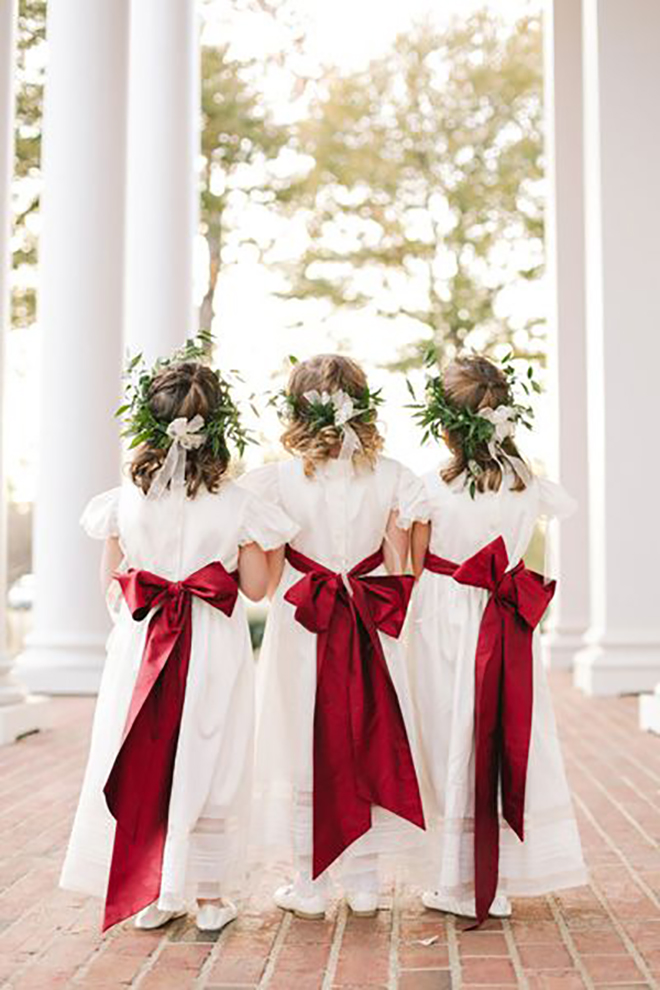 Flower girls in greenery crowns and red bows is the perfect touch of Christmas.