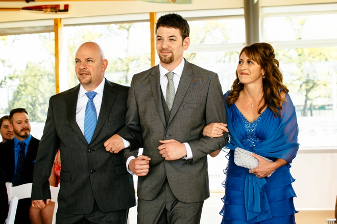 The groom and his parents walking down the aisle