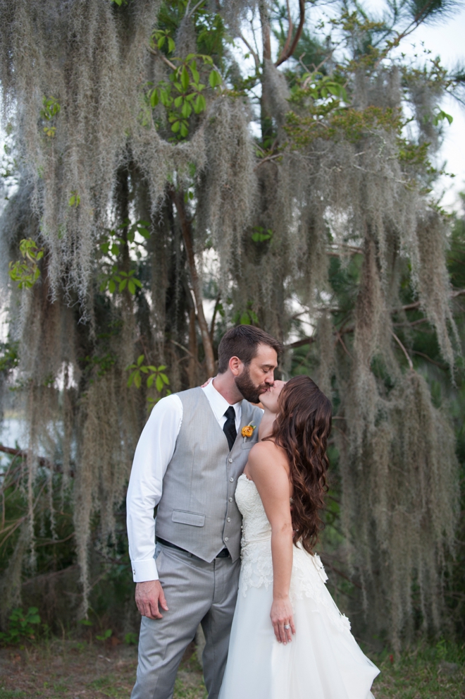 bride and groom kissing under giant tree