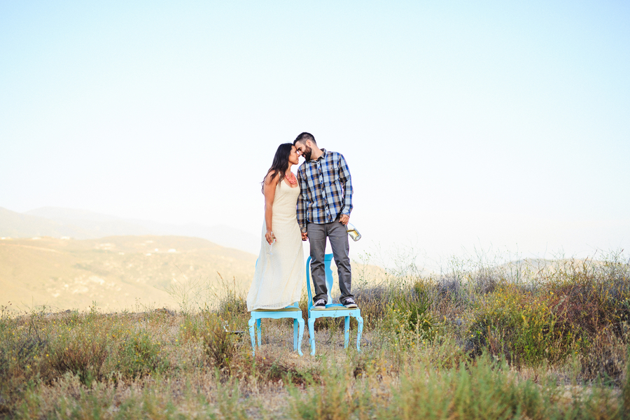 couple standing on chairs in the mountains