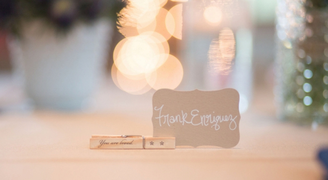 Handwritten seating cards held up by a clothespin