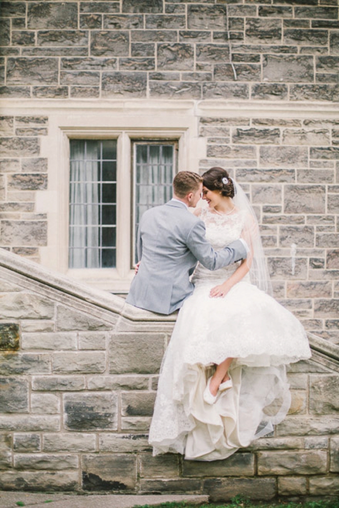 Bride and groom sitting on church wall