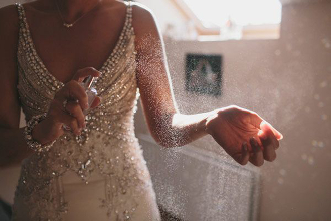 Bride spraying perfume.