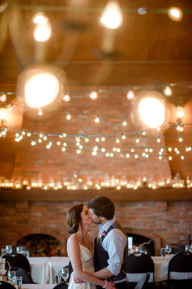 Bride and groom kissing under twinkle lights