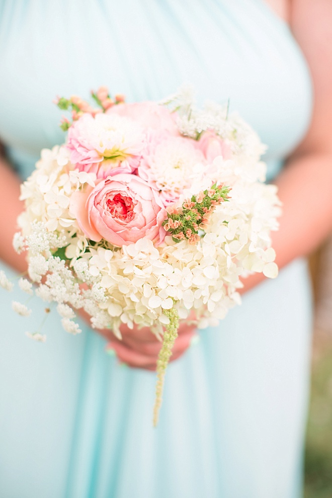Bridesmaid holding gorgeous bouquet full of cabbage roses, hydrangea and amaranthus