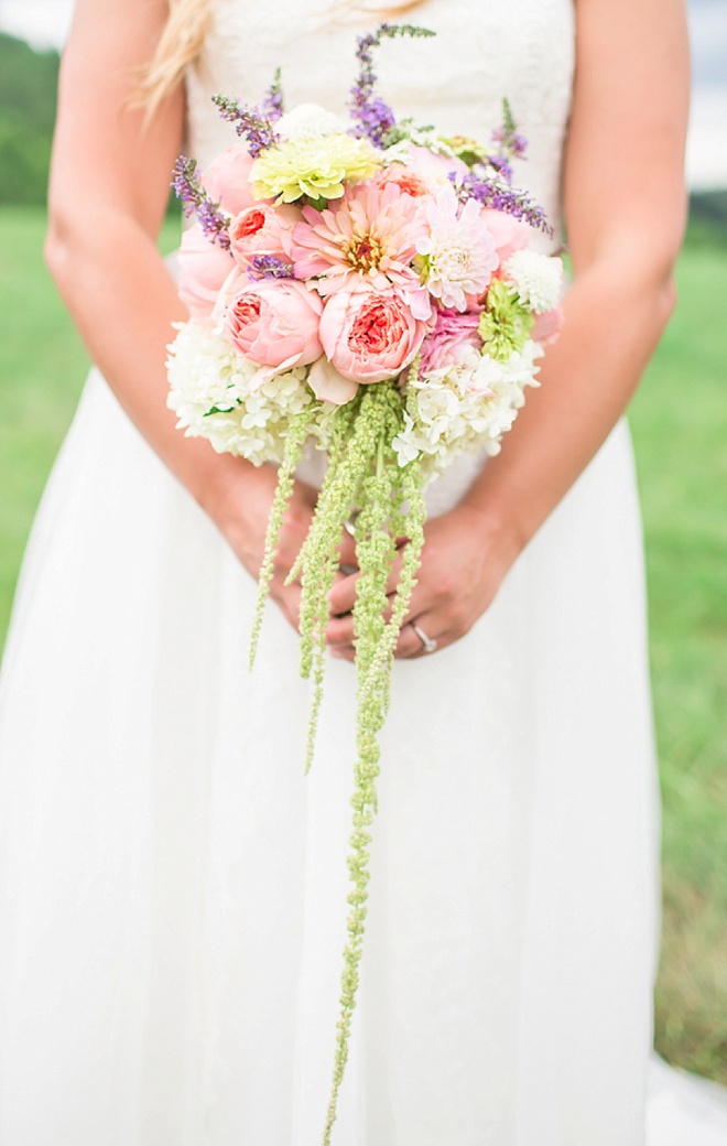 Bride holding gorgeous bouquet full of cabbage roses, hydrangea and amaranthus