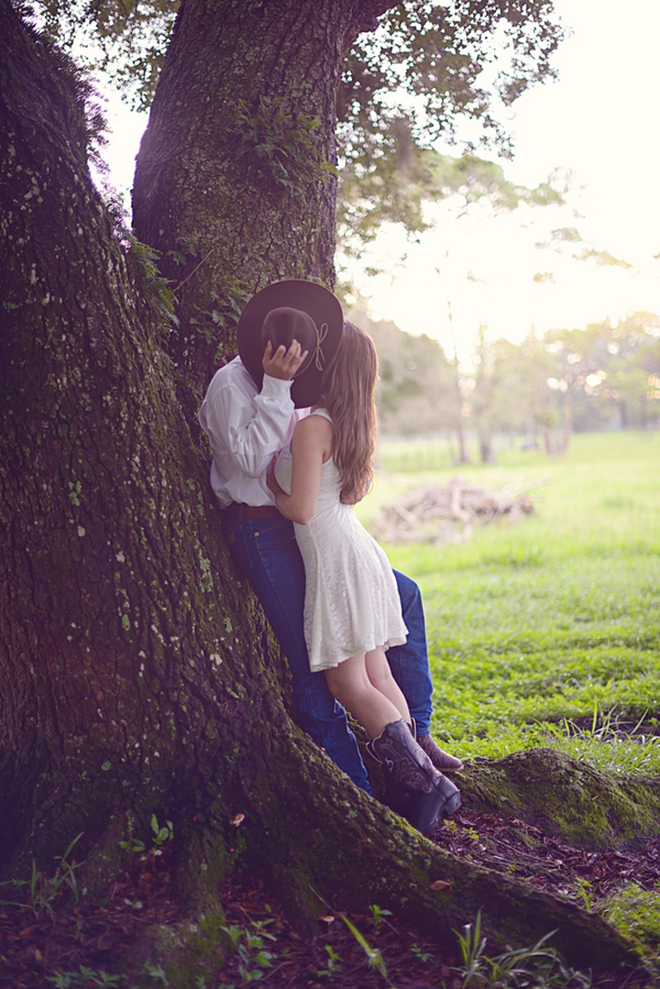Super sweet kiss behind a cowboy hat by Tiffany Danielle Photography