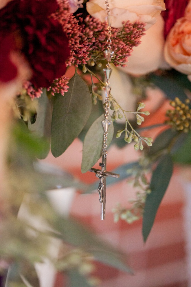 Rosary hanging from the brides bouquet.