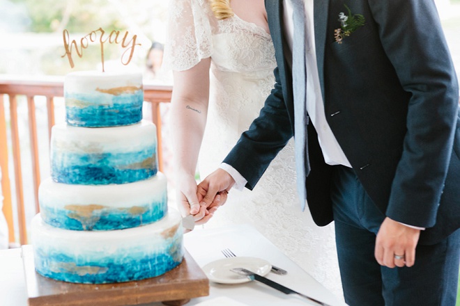 We're swooning over this handpainted blue wedding cake and darling hooray cake topper!