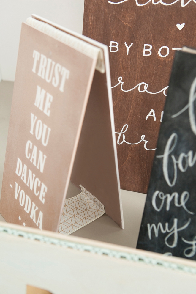 Using ribbon as hinges on these DIY wedding signs is a genius idea!