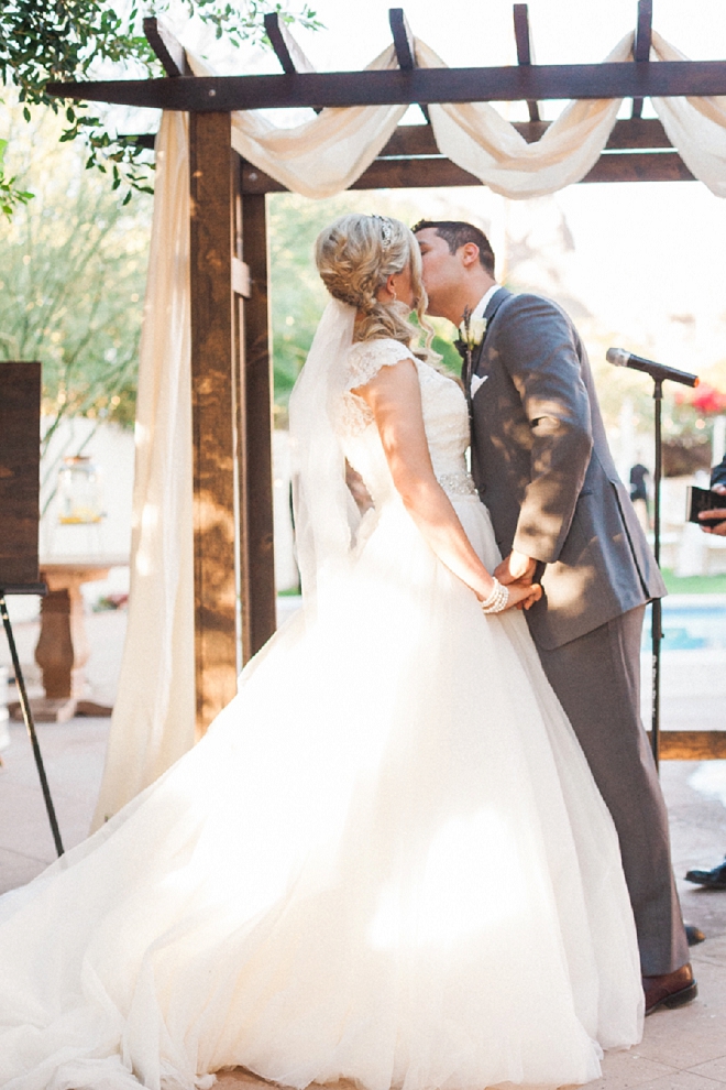 Swooning over this sweet outdoor desert ceremony and first kiss and Mr. and Mrs!