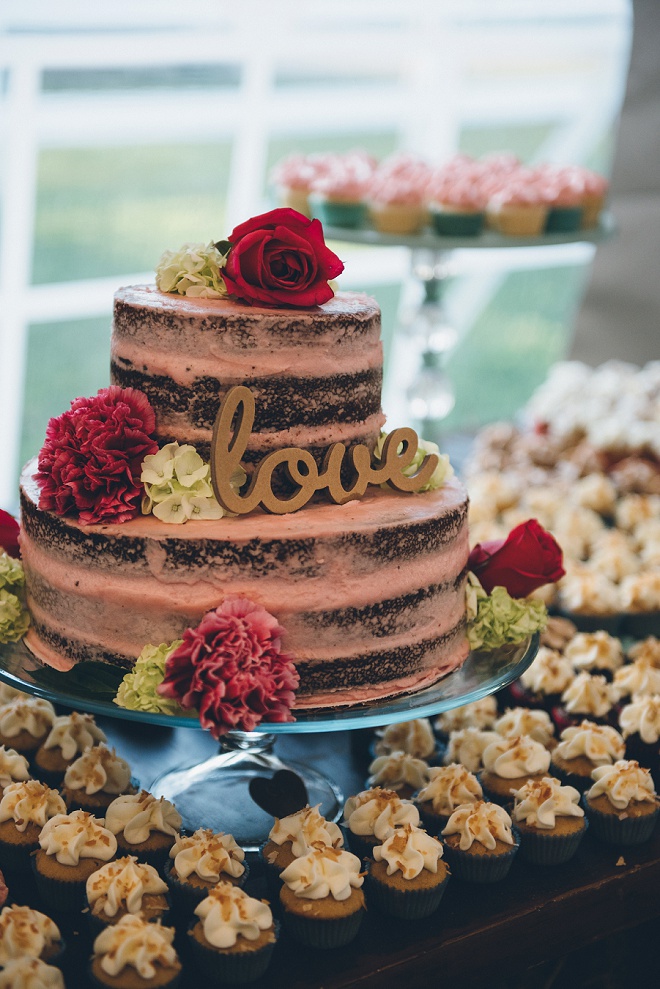 How gorgeous is this wedding cake with gold love cake topper and lots of cupcakes!