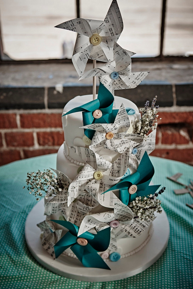 We're loving this gorgeous cake and DIY pinwheels out of music paper this fun Bride DIY'd for her UK wedding!!
