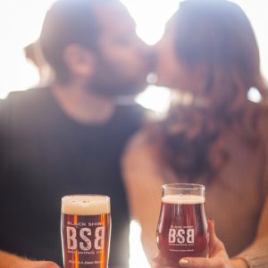 Darling shot of a beer loving couple kissing during their engagement shoot!