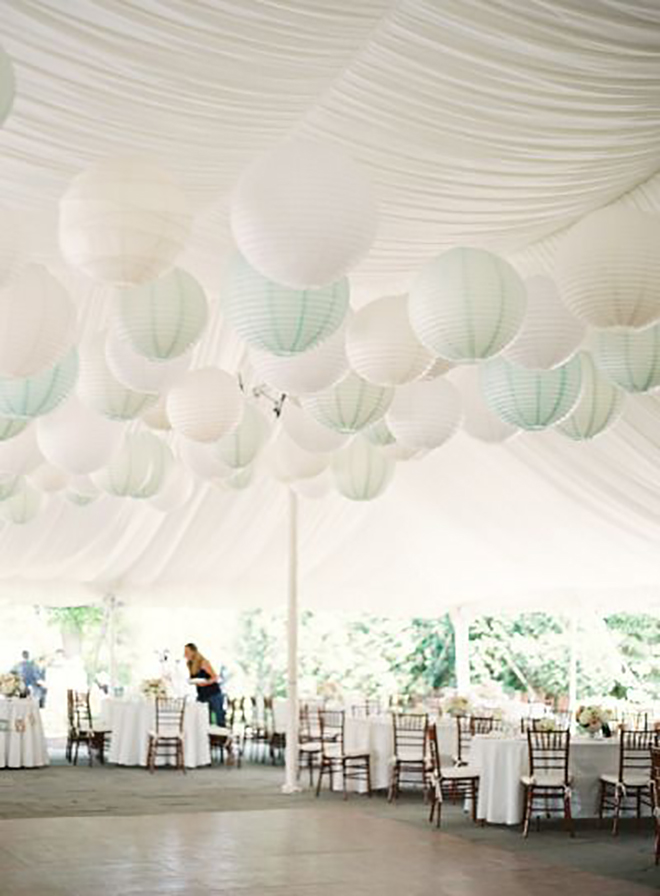 white paper lanterns against a white tent add texture and dimension 