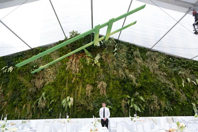 a wall of greenery in your wedding tent could not be more dreamy