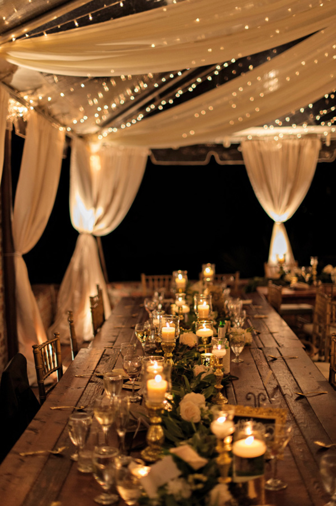 a combination of fabric and twinkle lights make for a beautiful layered look in a wedding tent