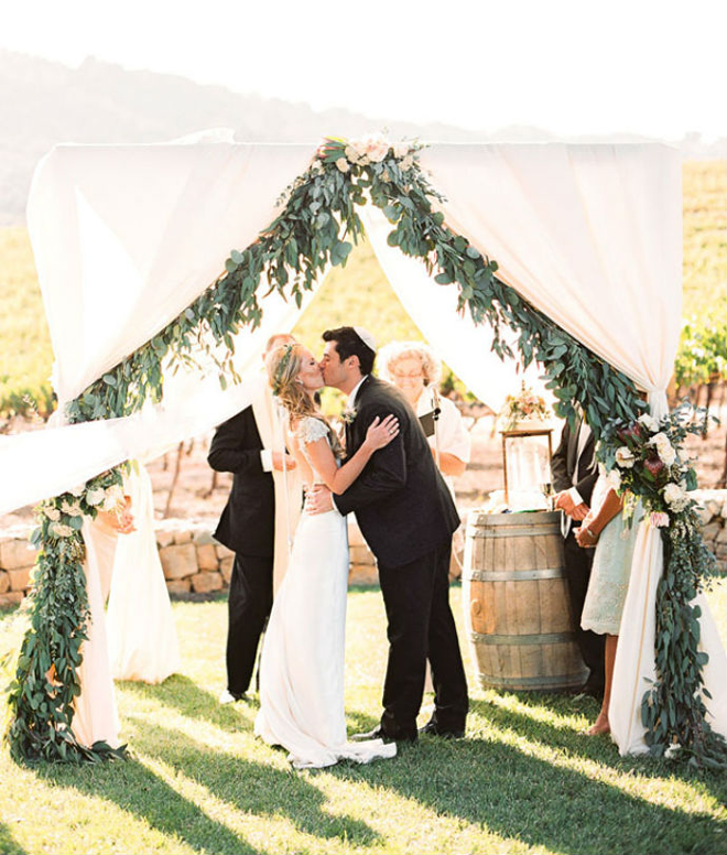 How romantic eucalyptus garland and fabric ceremony background!