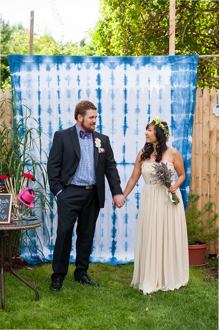 Loving the photo booth and hand dyed backdrop at this fun backyard wedding!