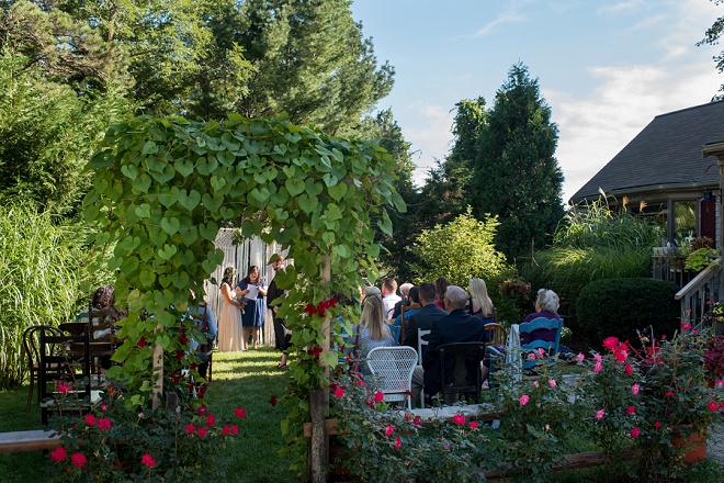 We love this peekaboo ceremony photo of their intimate backyard wedding!!