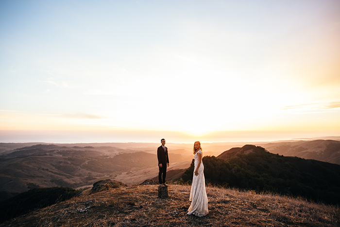 Stunning shot of the bride and groom on a cliff after their wedding, by JD Hudson