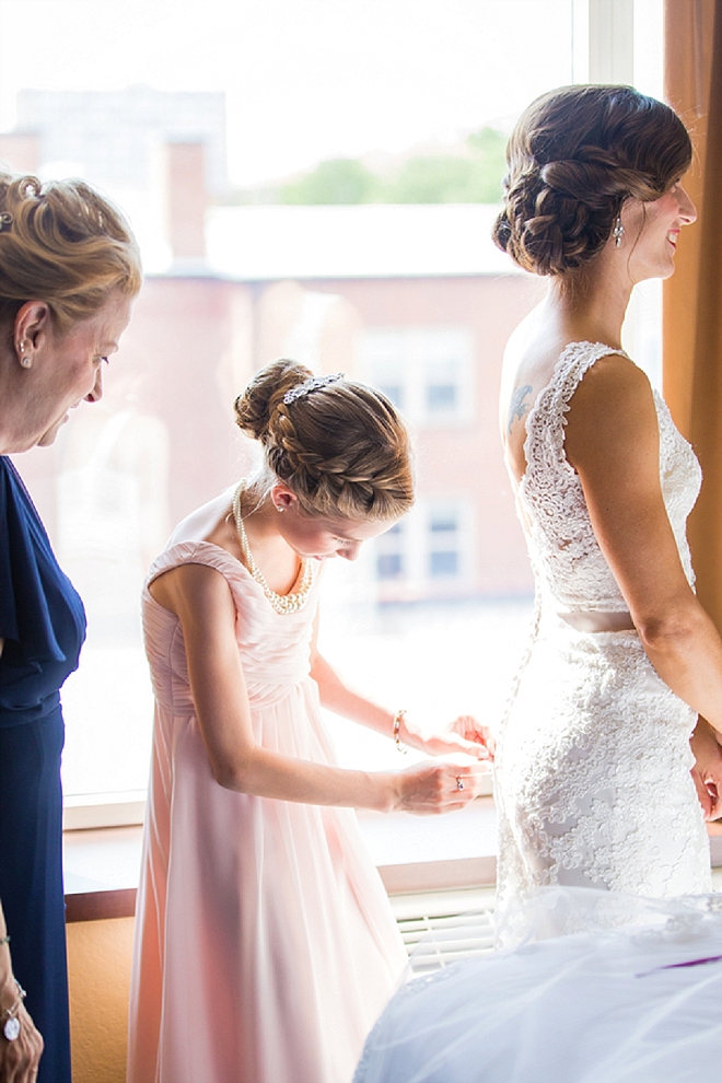 We love this snap of the Bride's mother and daughter helping her into her dress!