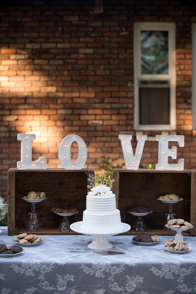 Gorgeous cake and LOVE sign at this couple's outdoor reception!