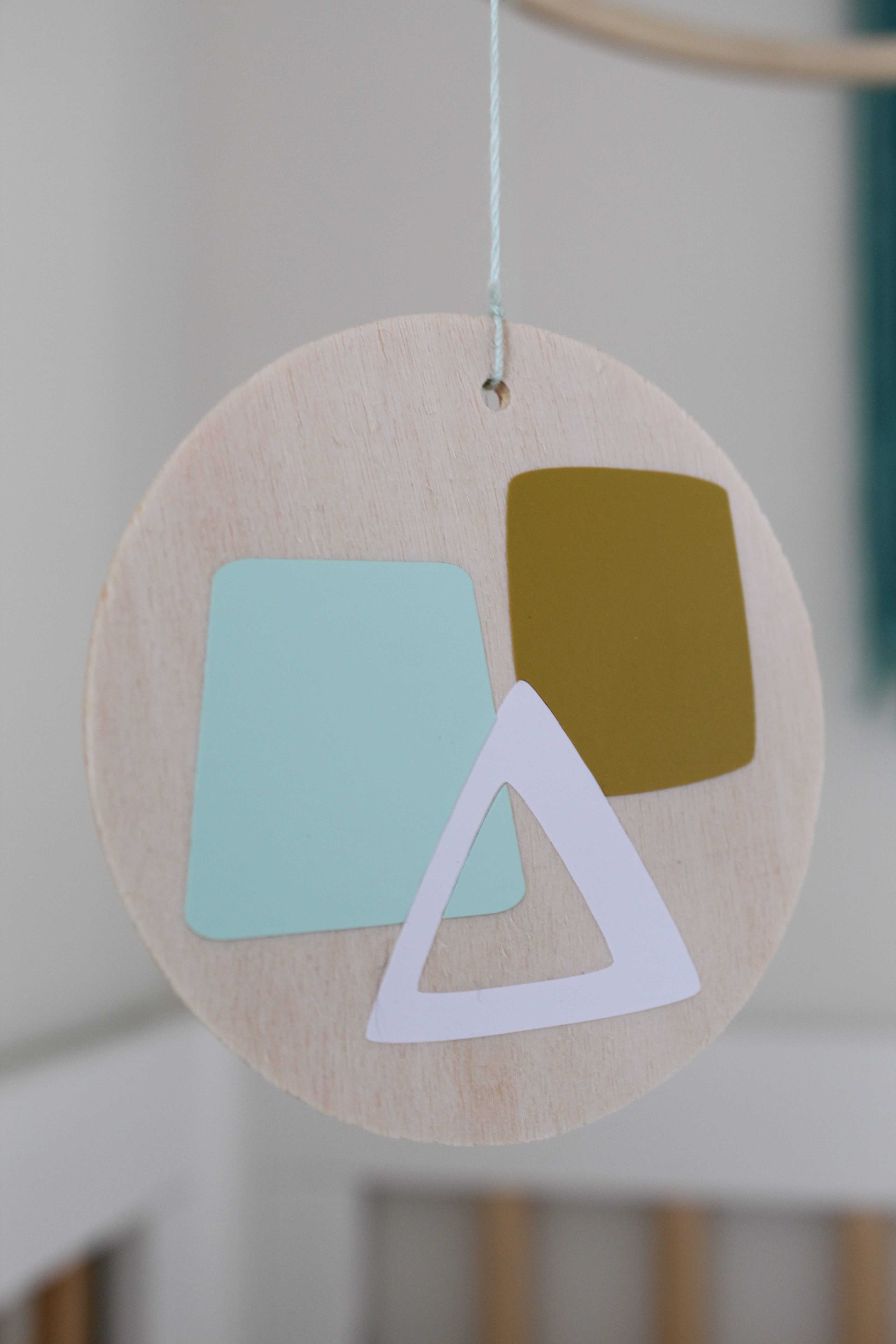 This DIY modern geometric nursery mobile is the perfect mix of form and function to hang over your beloved little one.